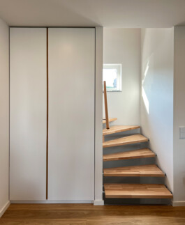 Asymmetrischer Einbauschrank im Flur mit weißen Fronten.