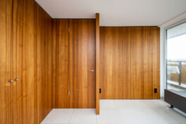 Raumtrenner mit Einbauschränken und furnierter Oberfläche.