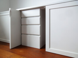 Weiß lackierter Schreibtisch mit verstecktem Schubkastencontainer und Fronten mit selbstkonstruiertem Öffnungsmechanismus.