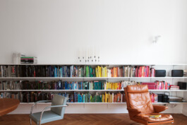 Einfaches Bücherregal aus weißen Böden und einem Regalsystem mit Wandschienen.