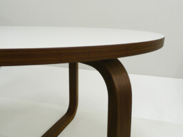 Runder Tisch mit Gestell aus gebogenem Massivholz und beschichteter Tischplatte mit Massivholzkante.