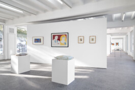 Ausstellungsansicht mit weißen Stellwänden und Sockeln 
