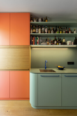 Küche in türkis und orange mit blauen Details, Unterschrank mit Rundung 