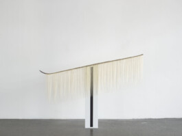 Objekt aus einem Skier, von dem helle lange Haare herunterhängen 