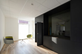 Ausbau einer Physiotherapie-Praxis nach Plänen von Rinnebach-Architektur. Schwarz-matter Plattenwerkstoff und abgedunkelte Scheiben. 