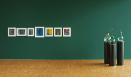 Skulpturen auf schwarzen runden Sockeln und Bilder vor einer grünen Wand im Kunstverein Heilbronn 