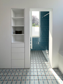 Weißer schmaler Einbauschrank in einer Nische im Badezimmer. 