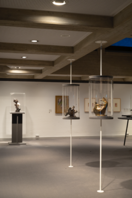 Zwei runde Vitrinen, die zwischen Decke und Boden gespannt sind. Im Hintergrund eine Vitrine mit eckigem Sockel. 