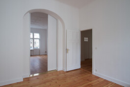 Eine zweiteilige asymmetrische Schiebetür für eine Öffnung mit Rundbogen in einem Altbau. 