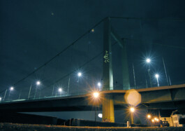 Nachtaufnahme einer Brücke mit Eurozeichen auf Stütze 
