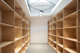 Lagerraum in Loft mit seitlich fast raumhohen Regalen aus Tischlerplatte.