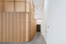 Trennwand aus Lamellen mit gerundeter Ecke in hellem Loft.