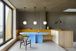 Hellblauer Hochglanz-Esstisch und Sitzbank mit senfgelbem groben Stoffbezug. 