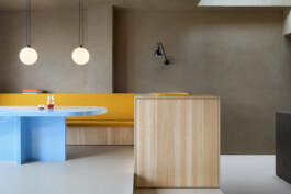 Hellblauer Hochglanz-Esstisch und Sitzbank mit senfgelbem groben Stoffbezug und hellblauer Esstisch mit Kugel-Leuchten. 