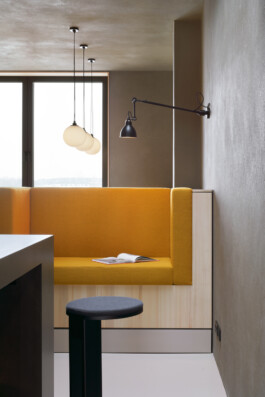 Detail einer Sitznische mit gelben Polstern. 