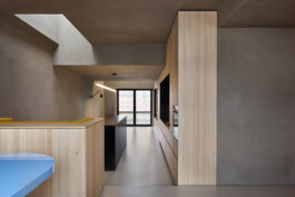 Langer Raum mit Oberlicht und Lehmputz und einer Küchenzeile mit Küchenblock. 