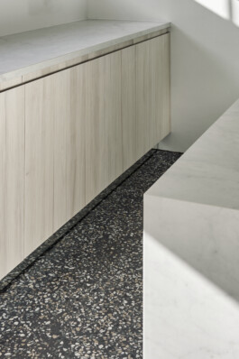 Küchen-Unterschränke mit Fronten aus weiß geölter Weißtanne-Dreischichtplatte und Gussterazzoboden. 