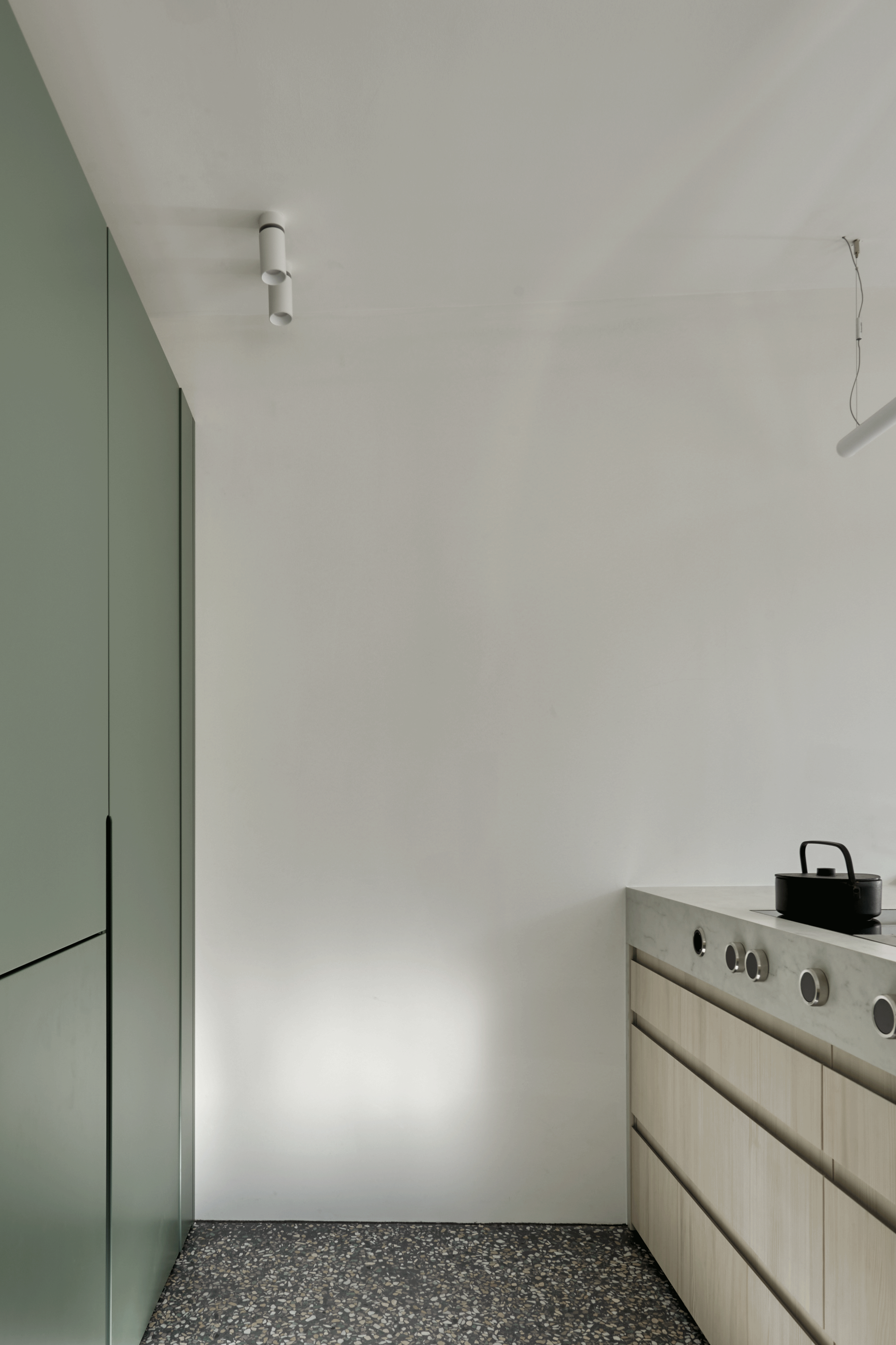 Detail eines matt-grünem Küchenschranks mit individuell gefertigten Gewürzregal. 