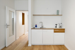 Weiße Küche mit Details aus Massivholz. 