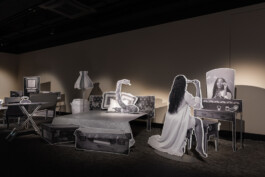 Installation aus mit Schwarzweiß-Fotografien bedruckten Objekten, die die Möblierung eines Schlafzimmers bilden.