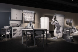 Installation aus mit Schwarzweiß-Fotografien bedruckten Objekten, die die Möblierung einer Küche bilden.