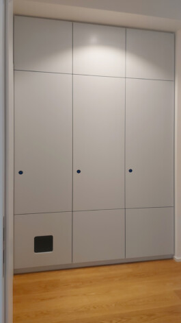 Dreigeteilter Einbauschrank in pastellblau mit runden Griffräsungen und einem verstecken Katzenklo.